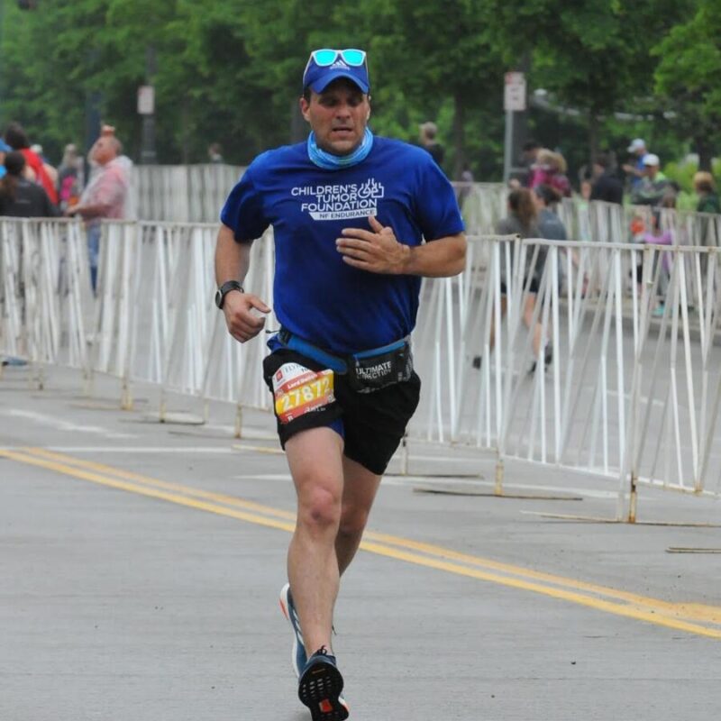 A man running in a blue shirt and shorts.