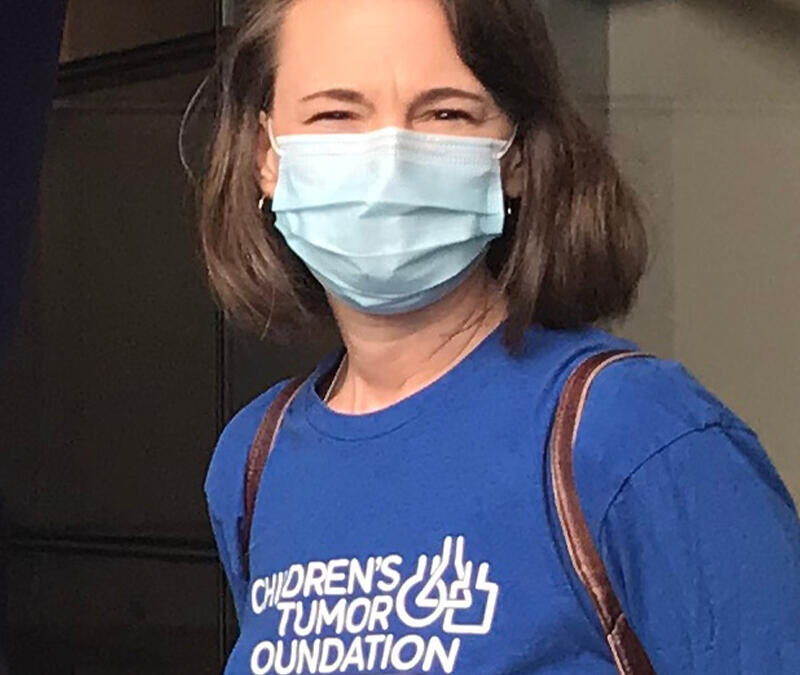 A woman wearing a surgical mask and a man wearing a t - shirt.