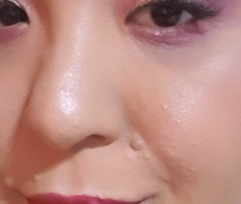 A close up of a woman with pink makeup on her face.