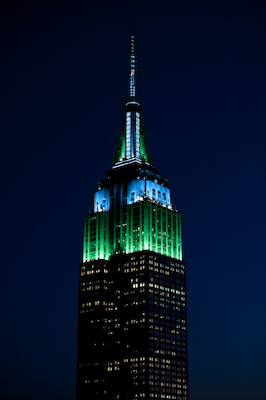 The empire state building is lit up in green.