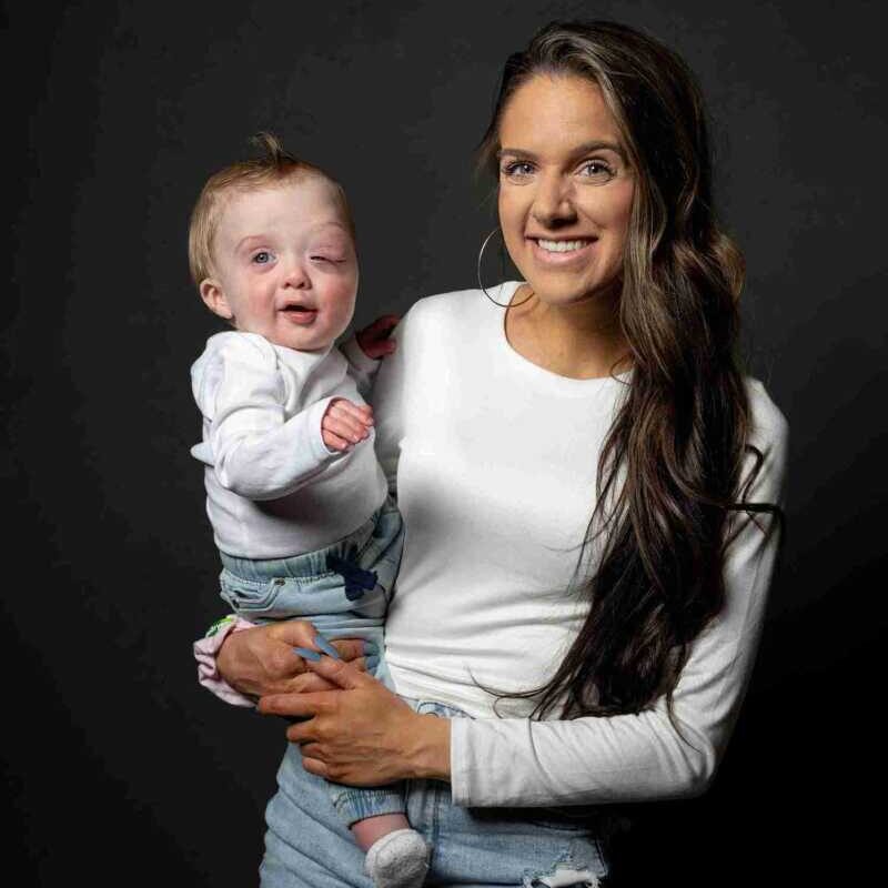 A woman holding a baby on a black background.