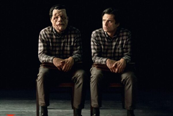 Poster for "A Different Man" featuring two men sitting side by side, one with facial disfigurement, against a dark background. Text at the bottom includes the cast and film credits.