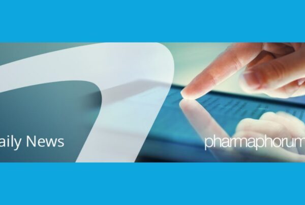 A close-up of a person using a tablet with text "Daily News" on the left and "pharmaphorum" on the right over a blue and white background.