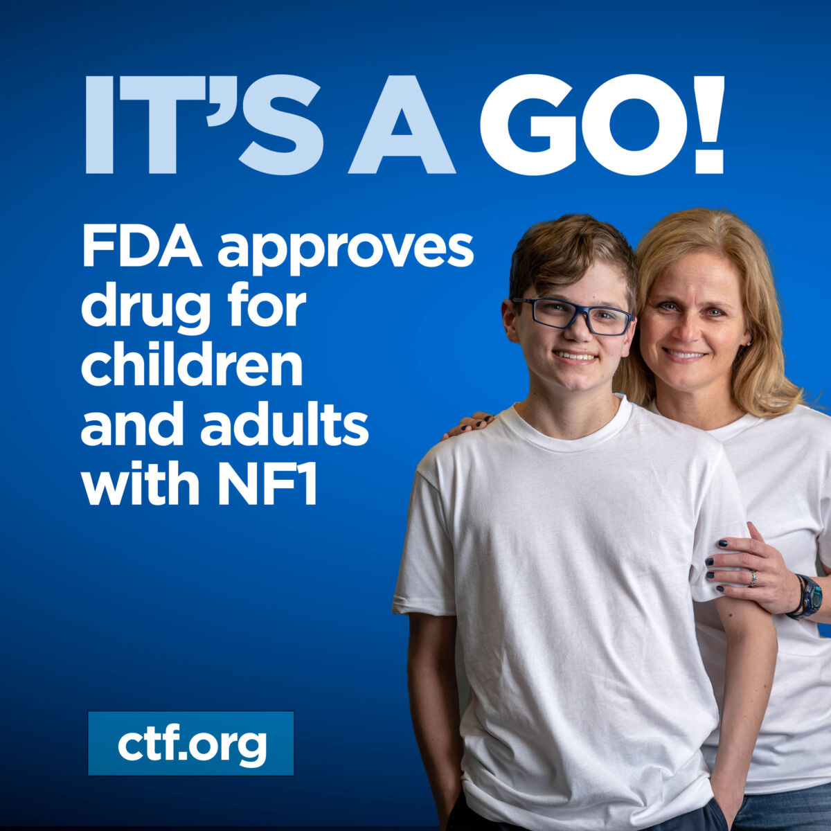 Two people smiling in front of a blue background with text announcing FDA approval of a drug for children and adults with NF1.